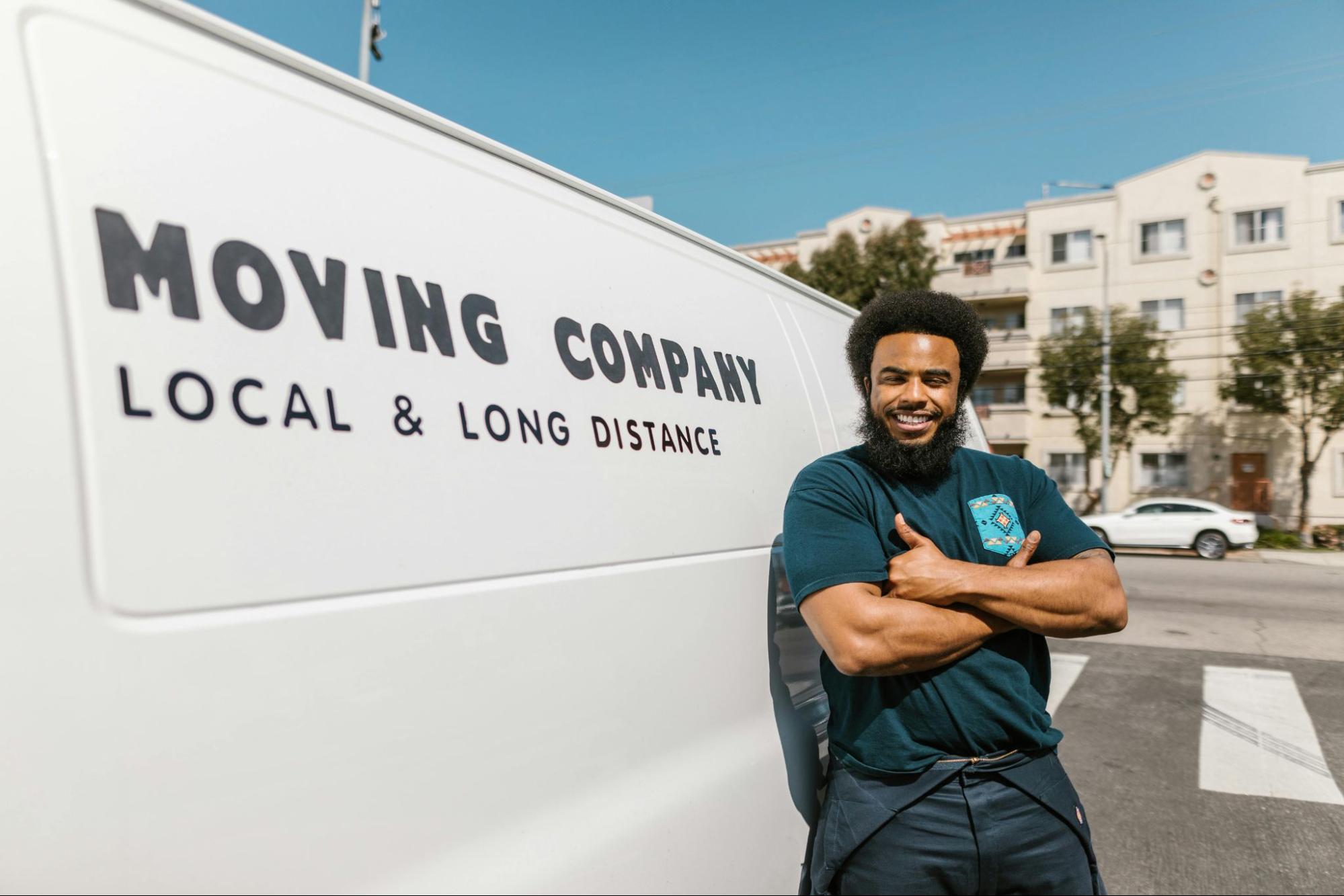 Professional mover standing next to a white moving van.