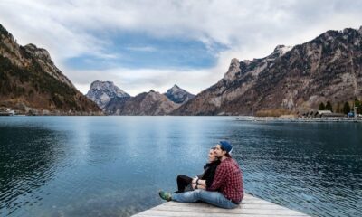 Free Man and Woman Sitting on Brown Wooden Dock Stock Photo